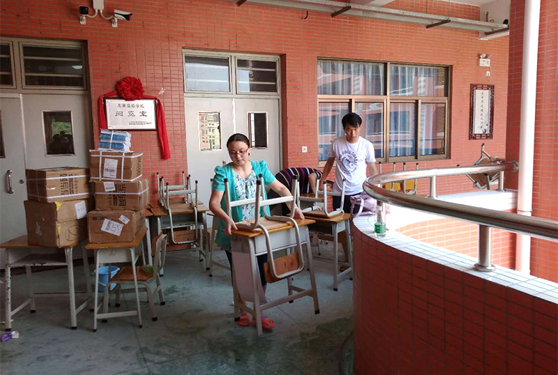 6686体育网页登录志愿者及家长用消毒液擦拭桌椅